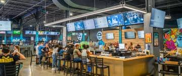 Overview of the bar and restaurant seating area inside Elev8, a family entertainment center (FEC) located inside a shopping mall